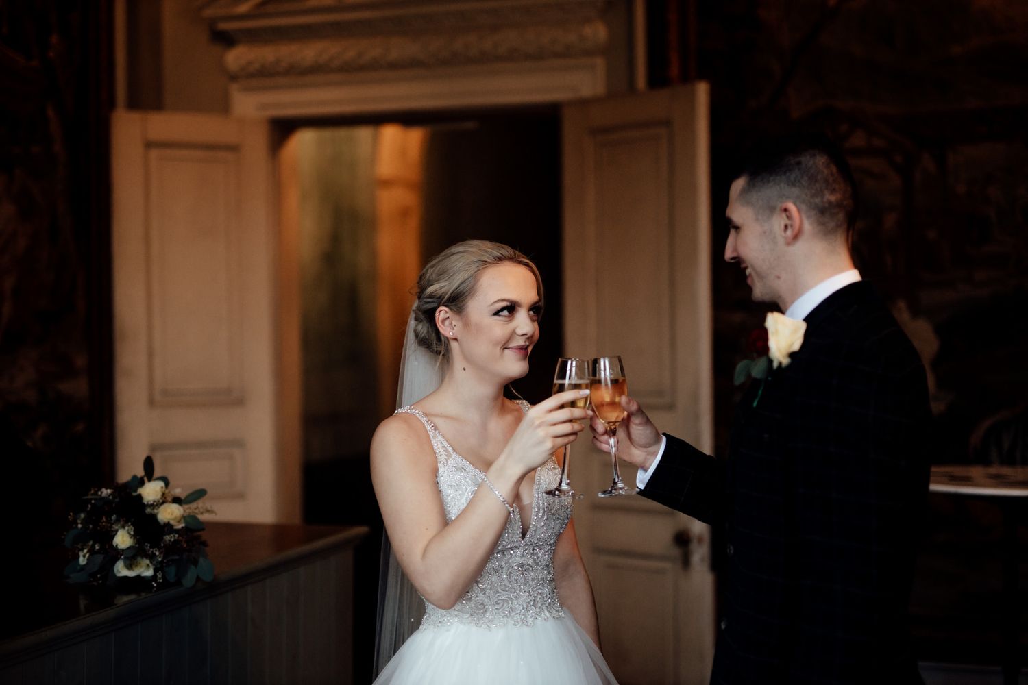 Wedding reception in a classic venue with warm lighting and elegant architectural details.