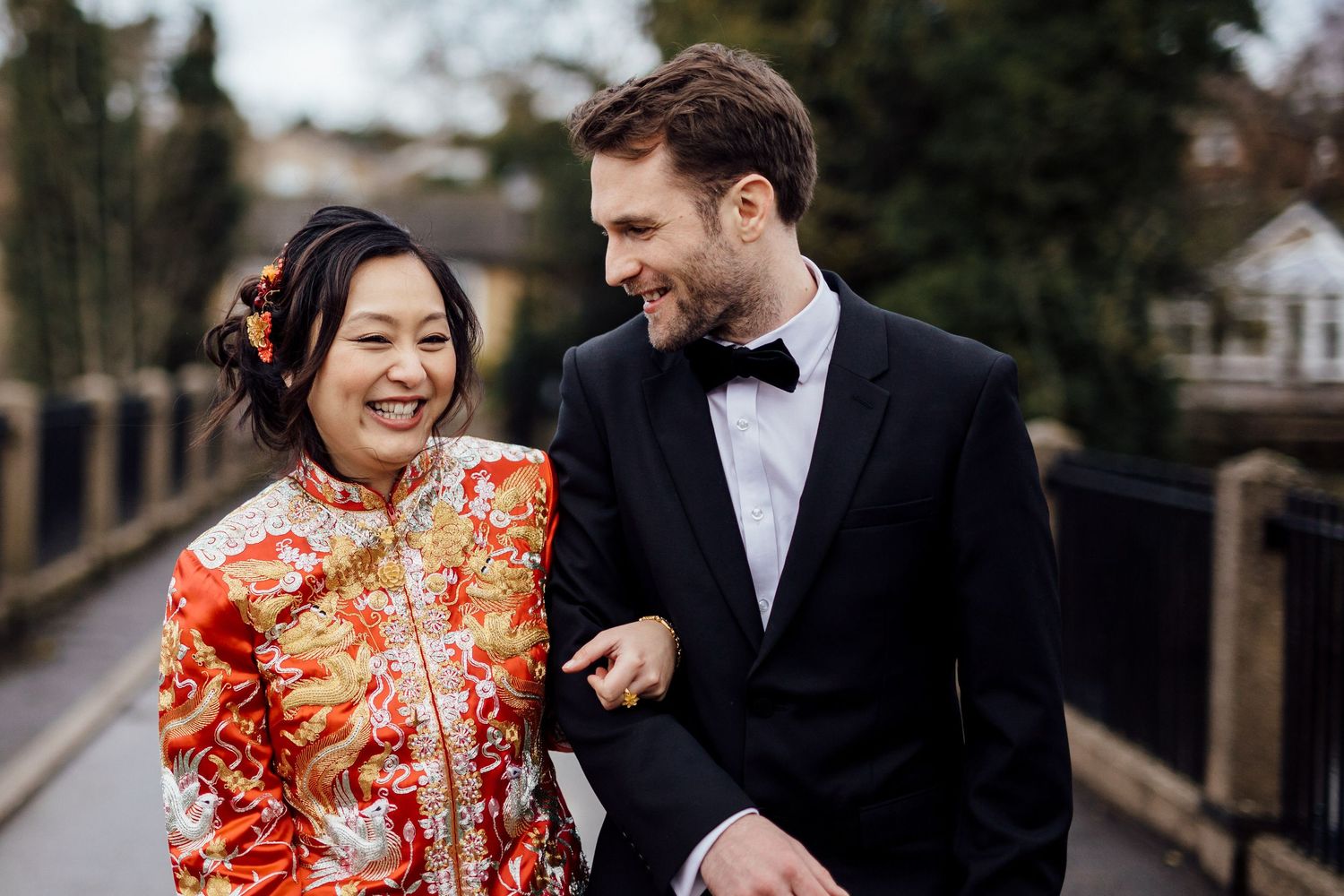 Couple sharing joyful moment outdoors in formal wedding attire.