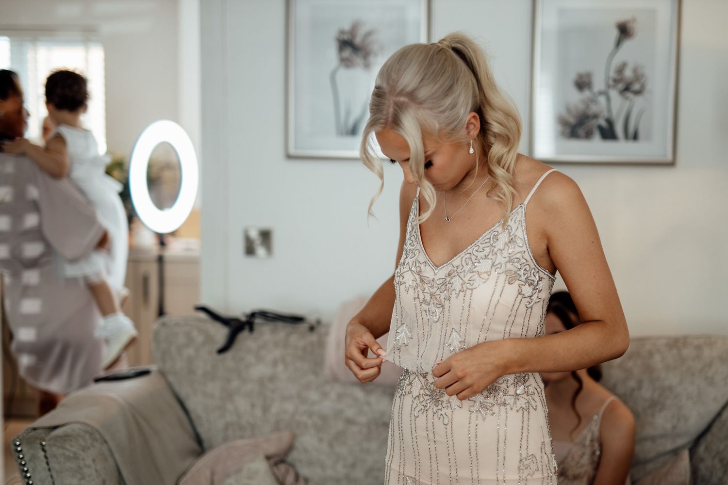 Getting ready moments captured in bright interior space with elegant wedding details.
