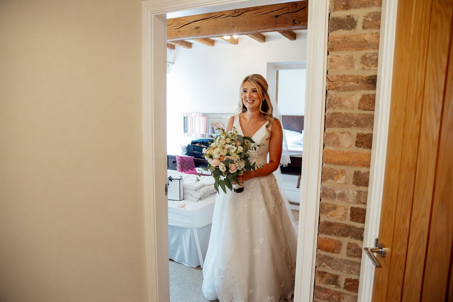 Bridal preparations in a rustic room with exposed brick walls and natural lighting.
