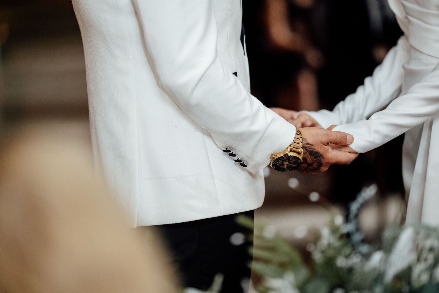 A couple shares an intimate moment during their first dance at a warmly lit wedding reception.