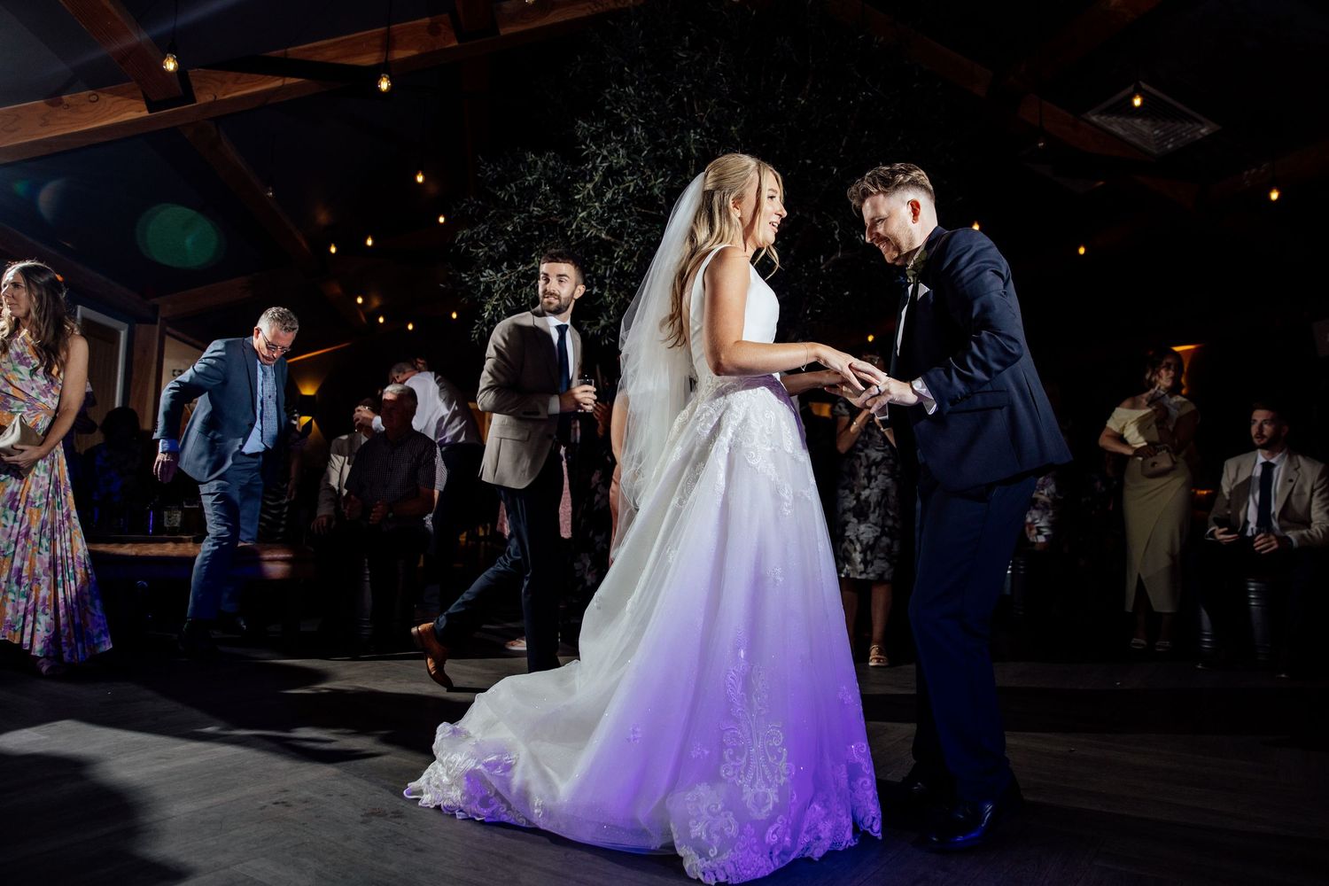 First dance at wedding reception with purple lighting effects.