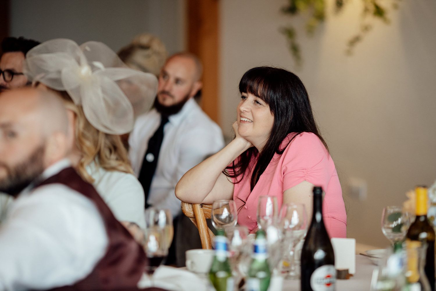 Wedding reception guests enjoying dinner at decorated tables.