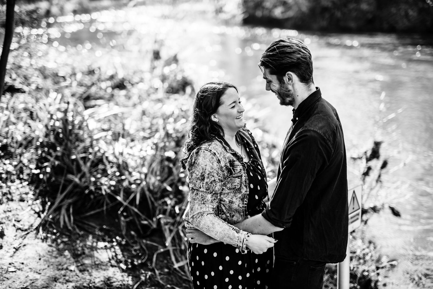 Black and white portrait of a couple sharing an intimate moment outdoors.