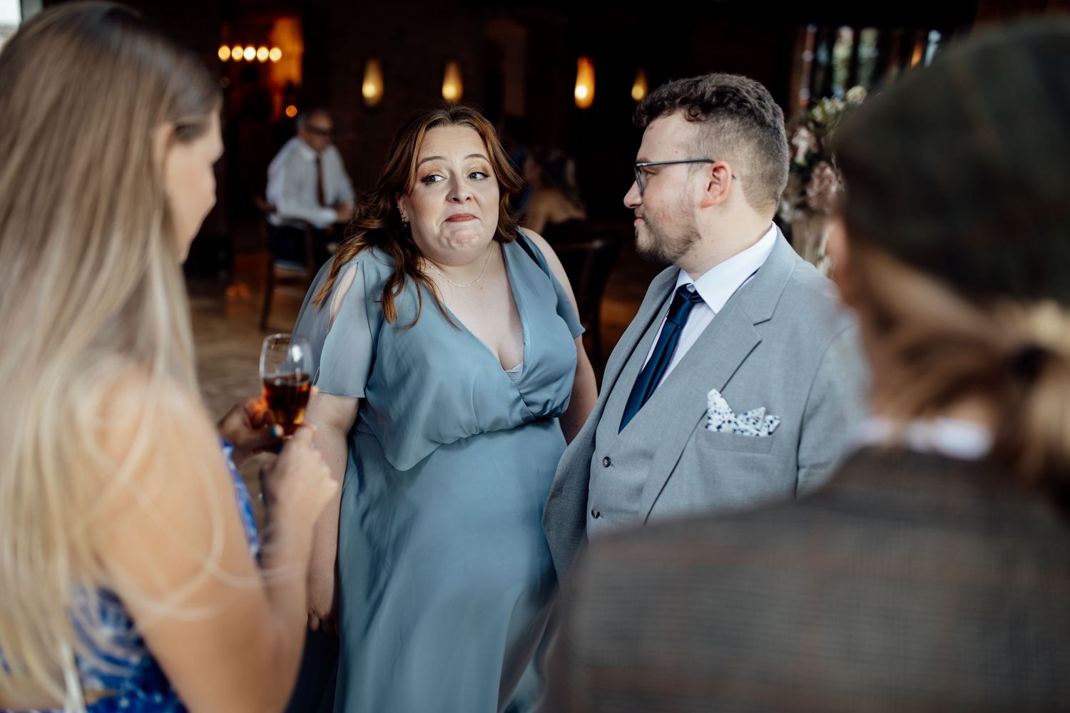 Candid moments captured during a wedding reception with guests mingling.