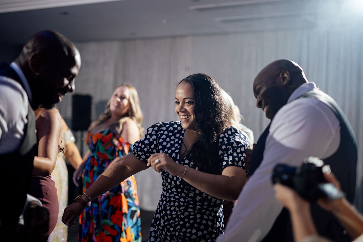Wedding reception guests dancing and enjoying themselves on the dance floor.