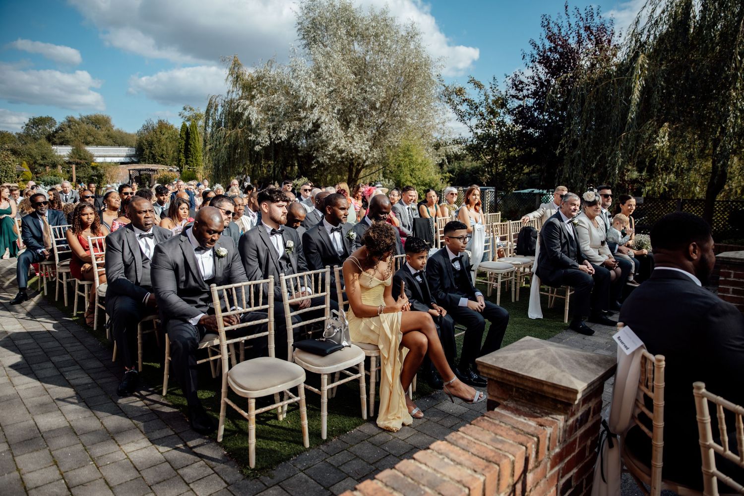 Outdoor wedding ceremony setup with white chairs under blue skies.