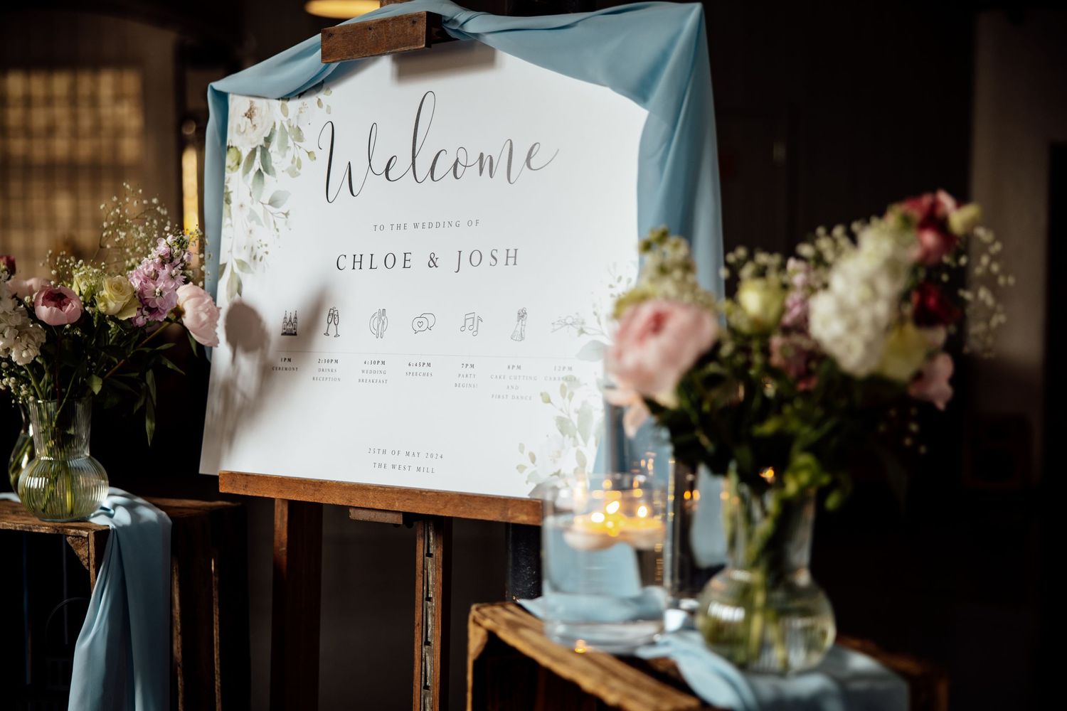 Wedding reception decor and welcome signs with floral arrangements.
