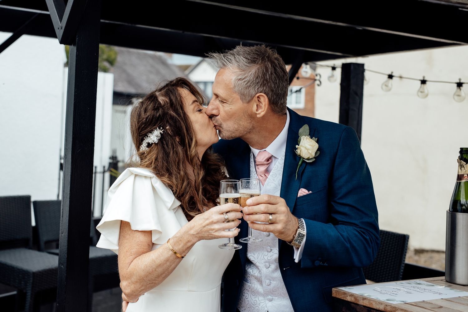 Couple sharing drinks at outdoor venue with festive atmosphere.