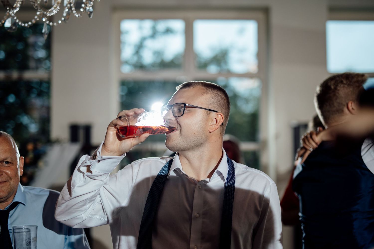 Wedding guests mingle and socialize during an indoor reception.