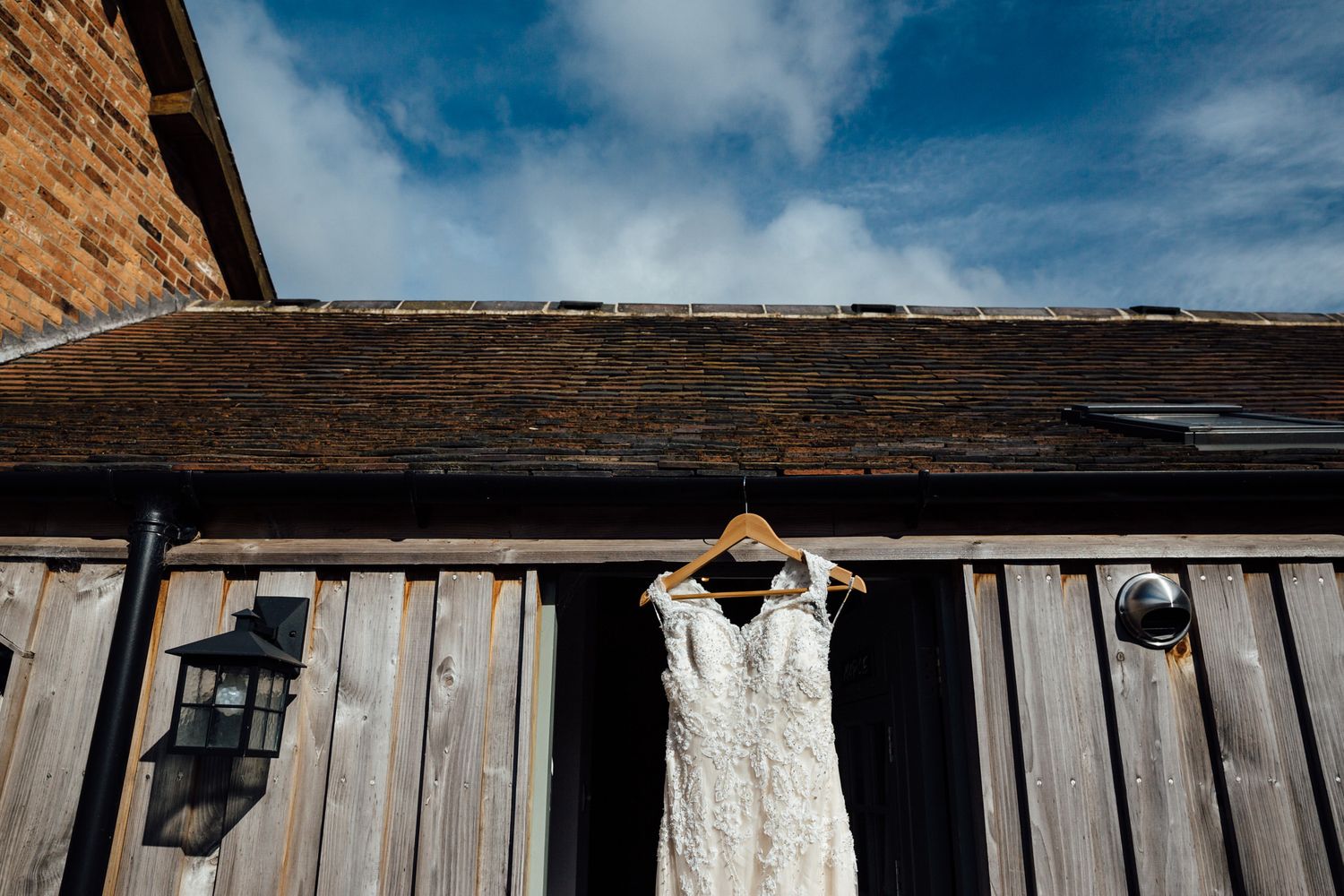 Rustic wooden barn exterior with vintage details against bright blue sky.