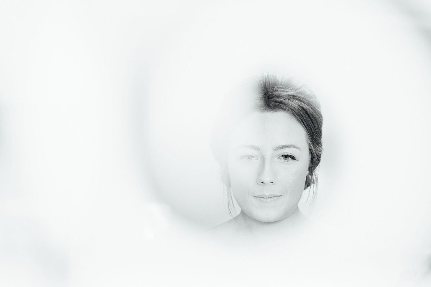 Artistic black and white close-up portrait showing soft focus and dreamy lighting effects.
