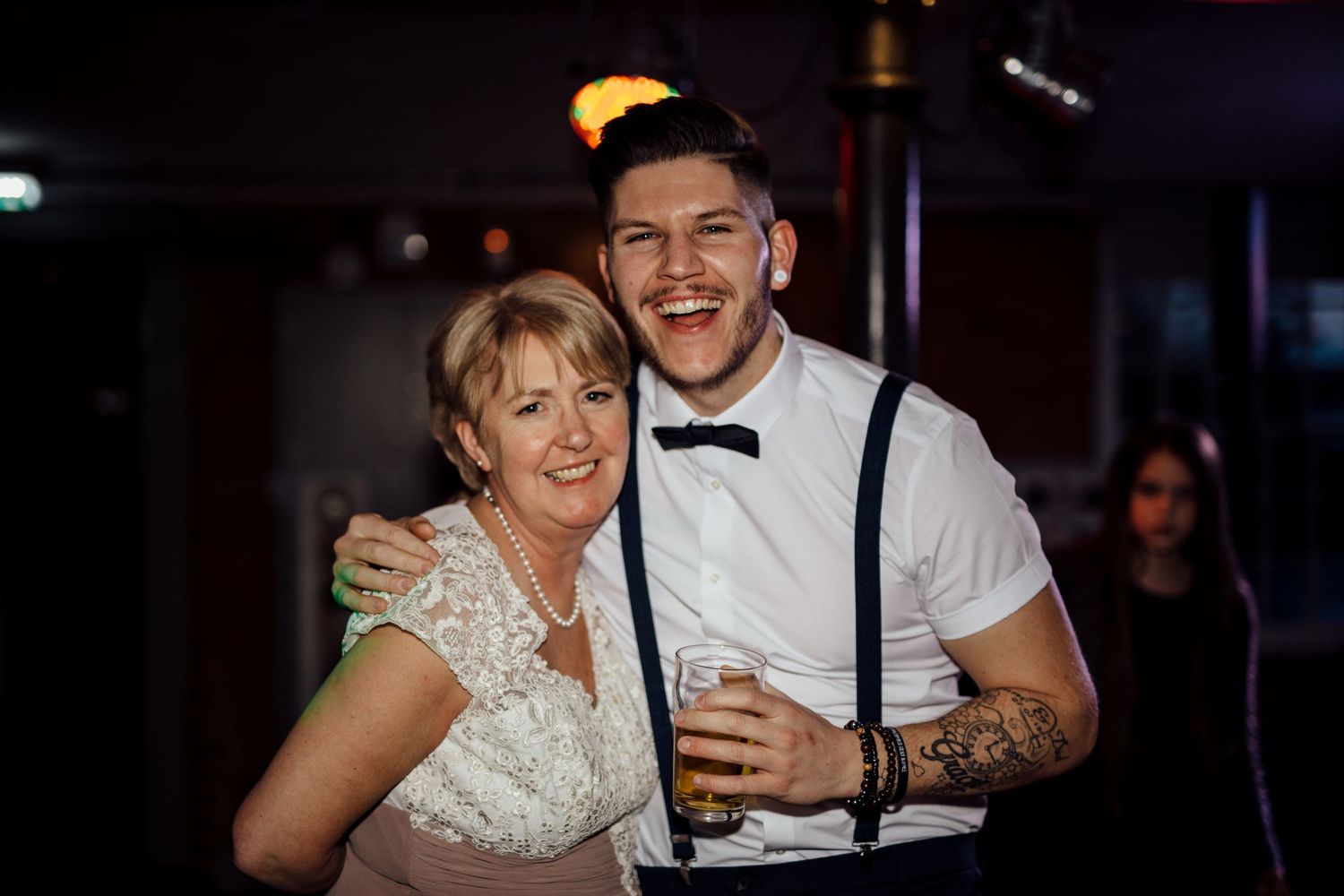 Wedding celebration on dance floor with festive lighting and joyful atmosphere.
