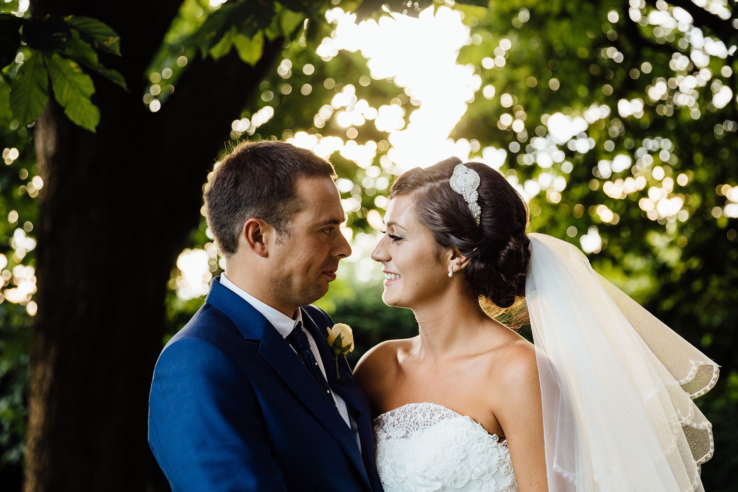 Romantic wedding couple portrait in a lush garden setting with natural sunlight.