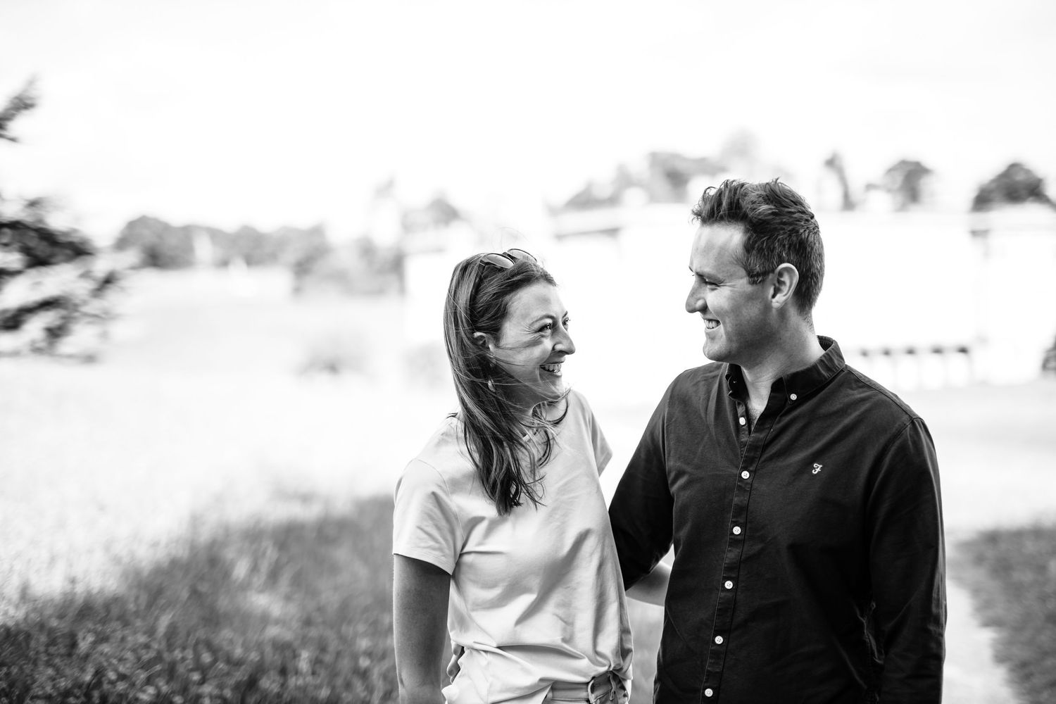 A tender black and white portrait of a couple sharing a romantic moment outdoors.