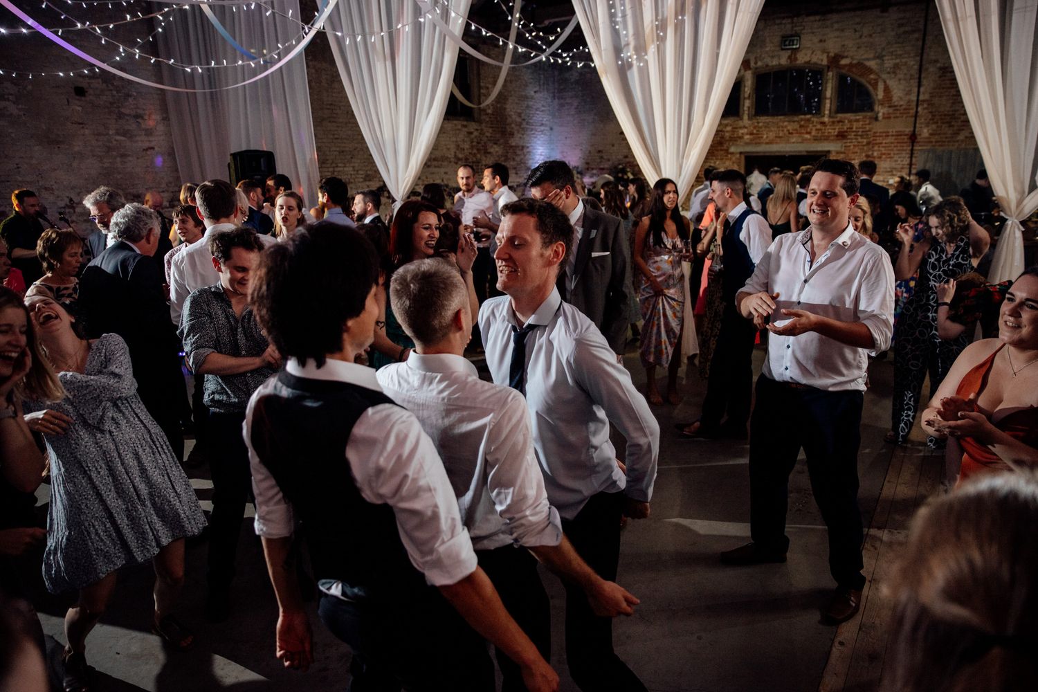Elegant wedding reception venue with white drapes and stone walls creating a romantic atmosphere.