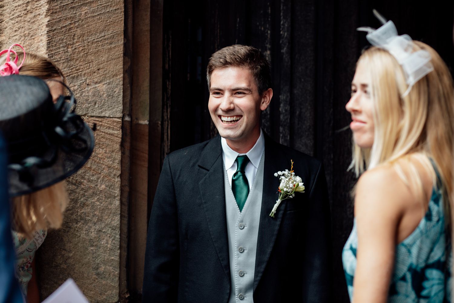 Wedding party members interacting during an outdoor ceremony.