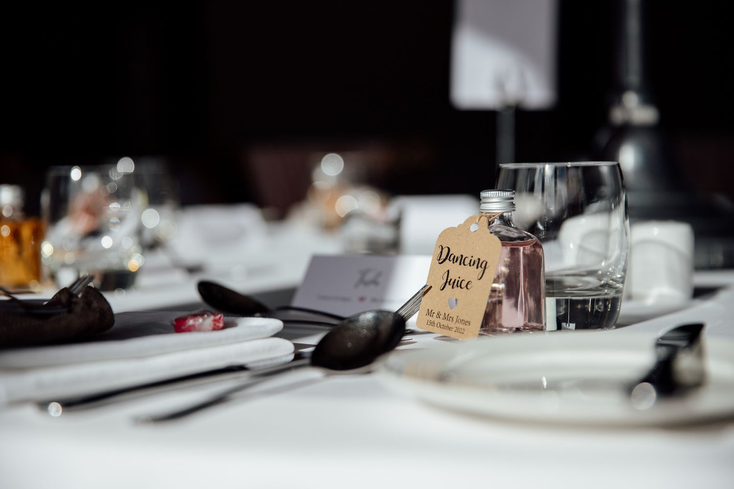 Elegant place settings and table decorations at a wedding reception.