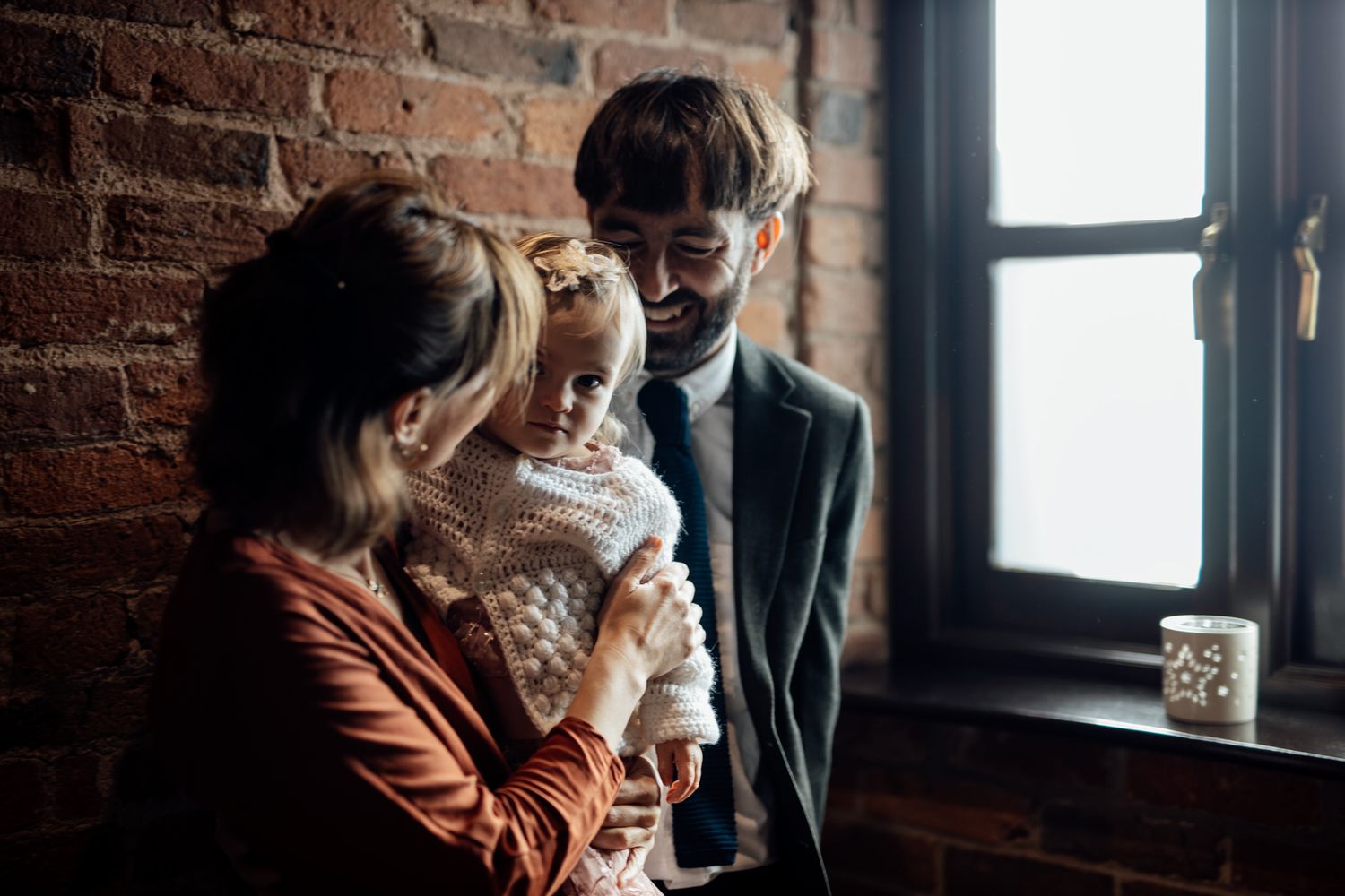 Cozy cafe scene with exposed brick walls and window lighting.