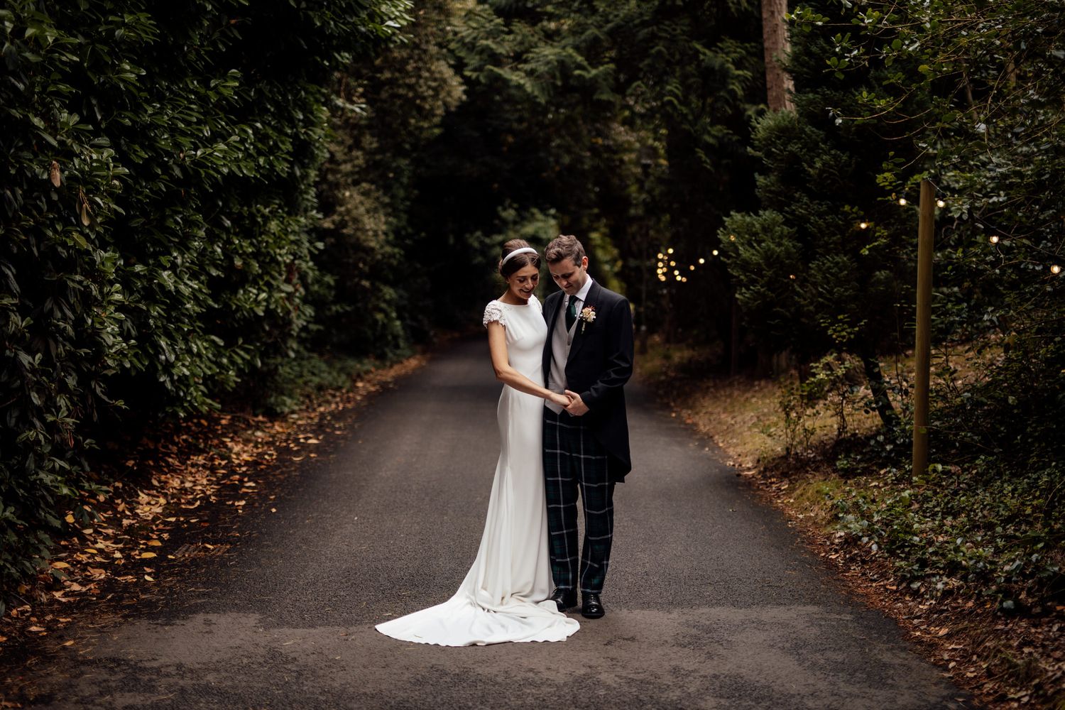 Romantic wedding portraits captured on a secluded forest pathway.