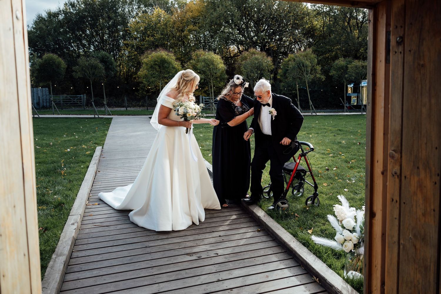 Wedding ceremony setup on wooden deck overlooking scenic natural landscape.