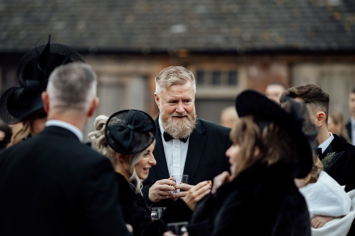 Wedding guests mingling during cocktail hour in formal attire.