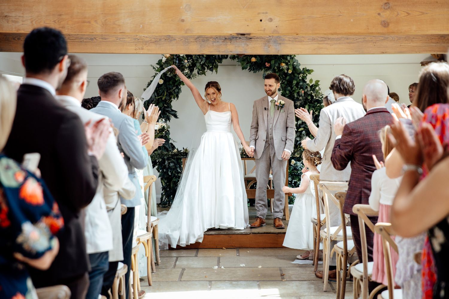 Wedding ceremony in progress inside a rustic wooden venue with natural decor.
