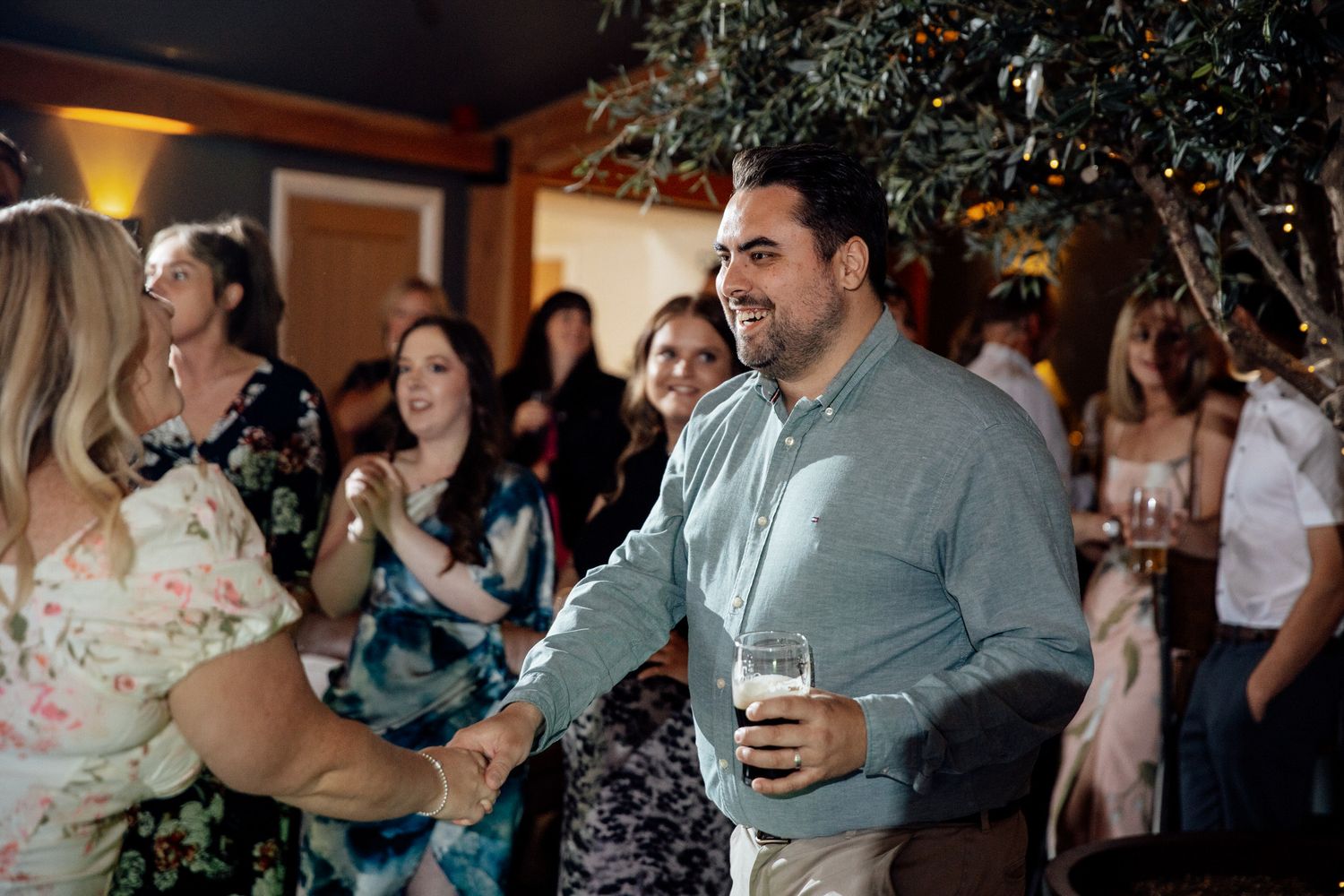 Wedding reception party with guests dancing and celebrating indoors.