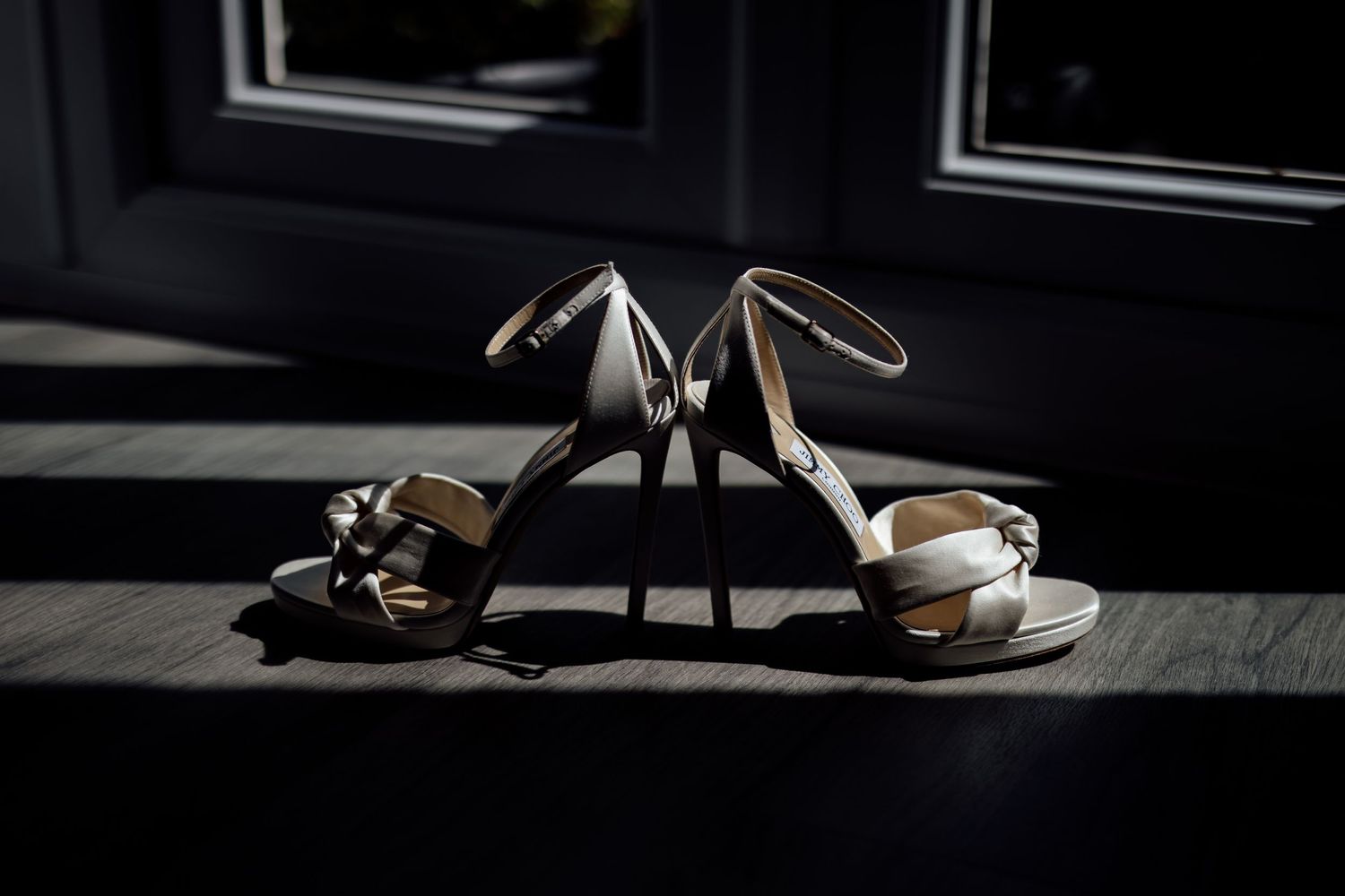 Elegant black and white wedding shoes displayed on dark surface.