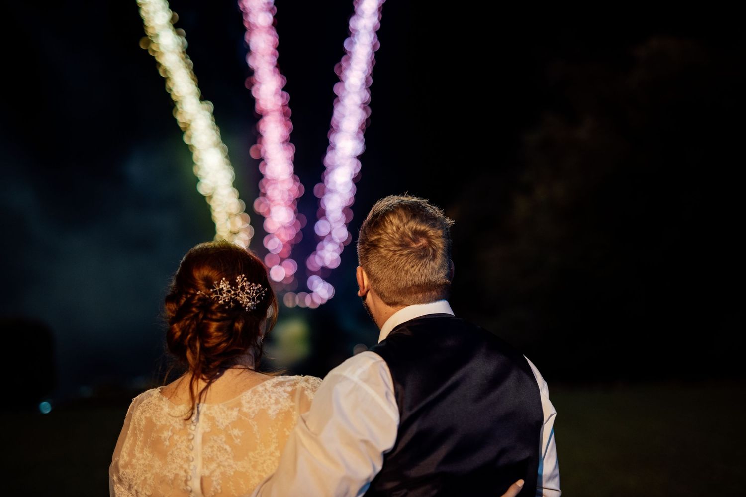 Wedding reception dance floor illuminated with colorful lighting and streamers.