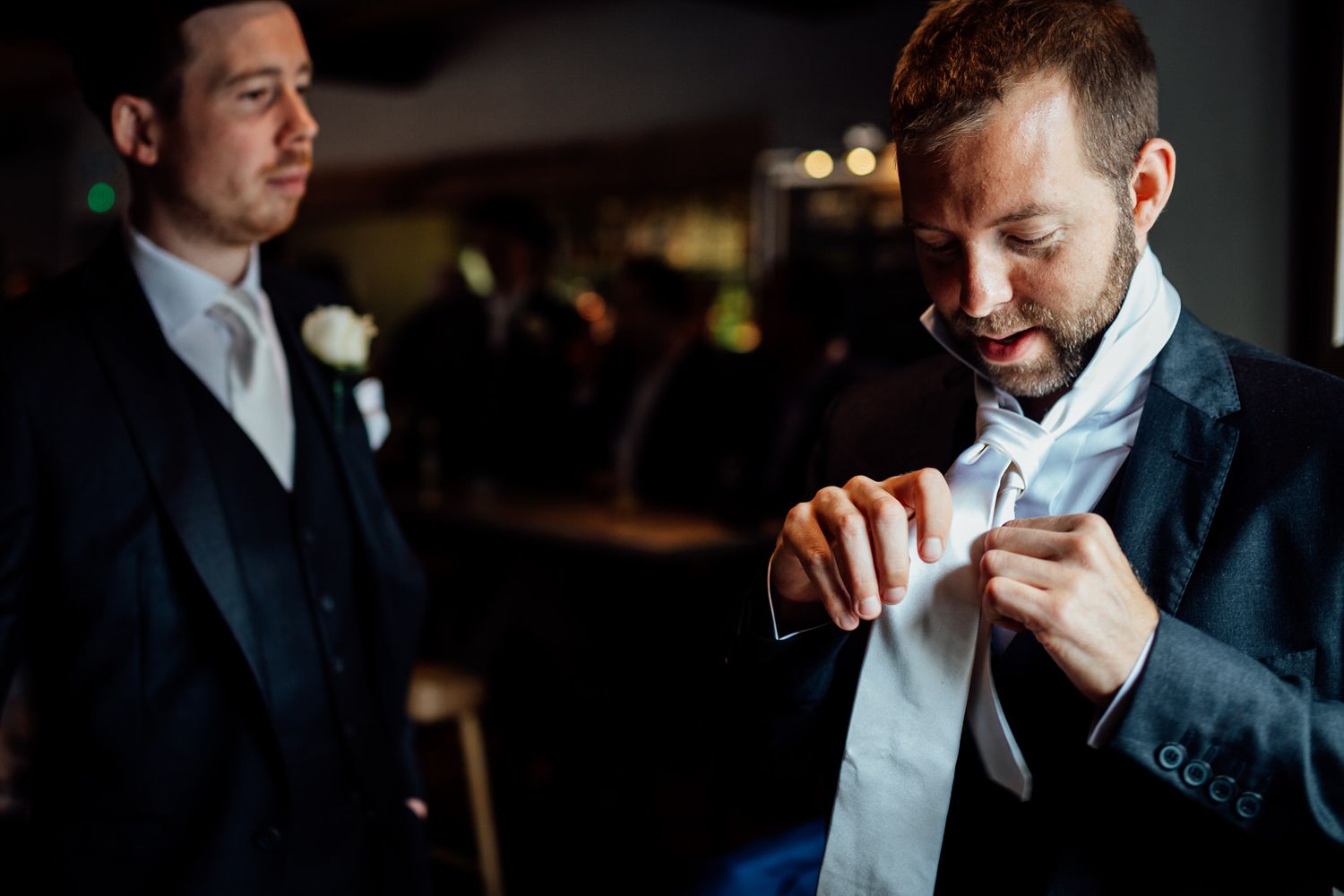 Groomsmen share emotional moment while getting ready for wedding ceremony.