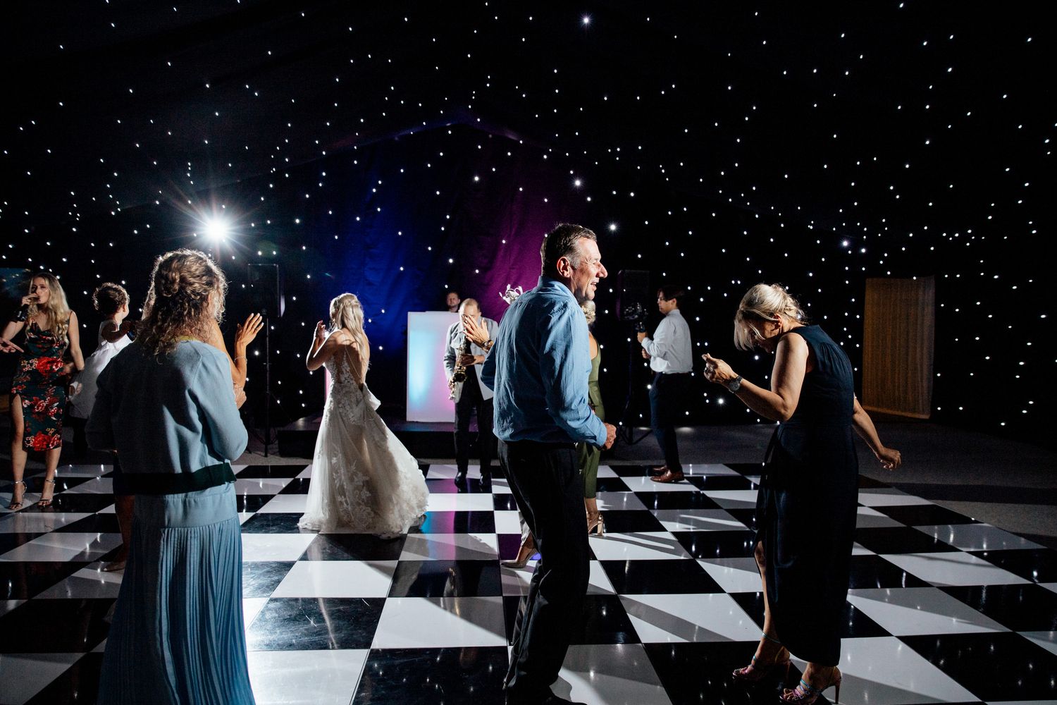 Wedding reception dance floor with starlit ceiling and checkered floor creates magical atmosphere.