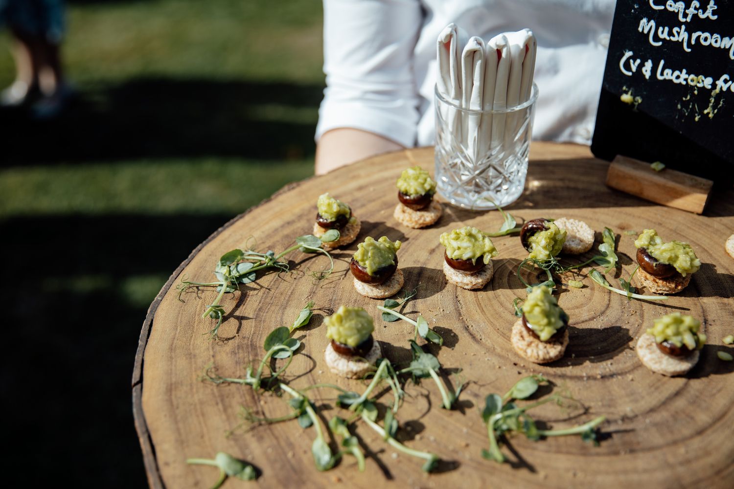 Elegant appetizers displayed on a wooden serving platter with garnishes.