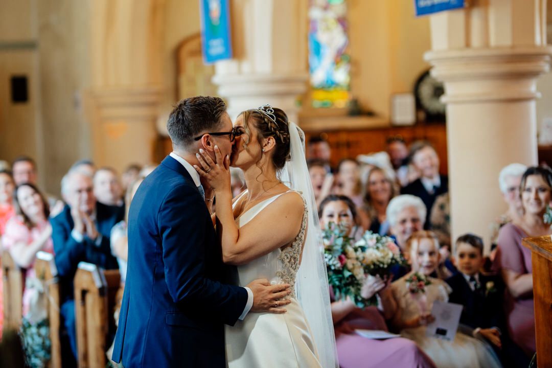 Romantic wedding ceremony taking place in ornate church sanctuary.