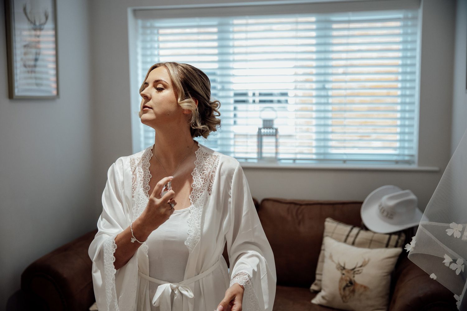 Getting ready moments captured in a bright modern room with white decor.
