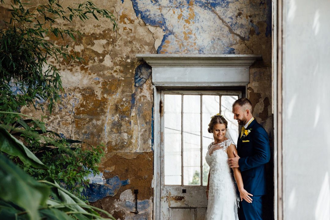 A rustic brick wall serves as a backdrop for a wedding day preparation scene.