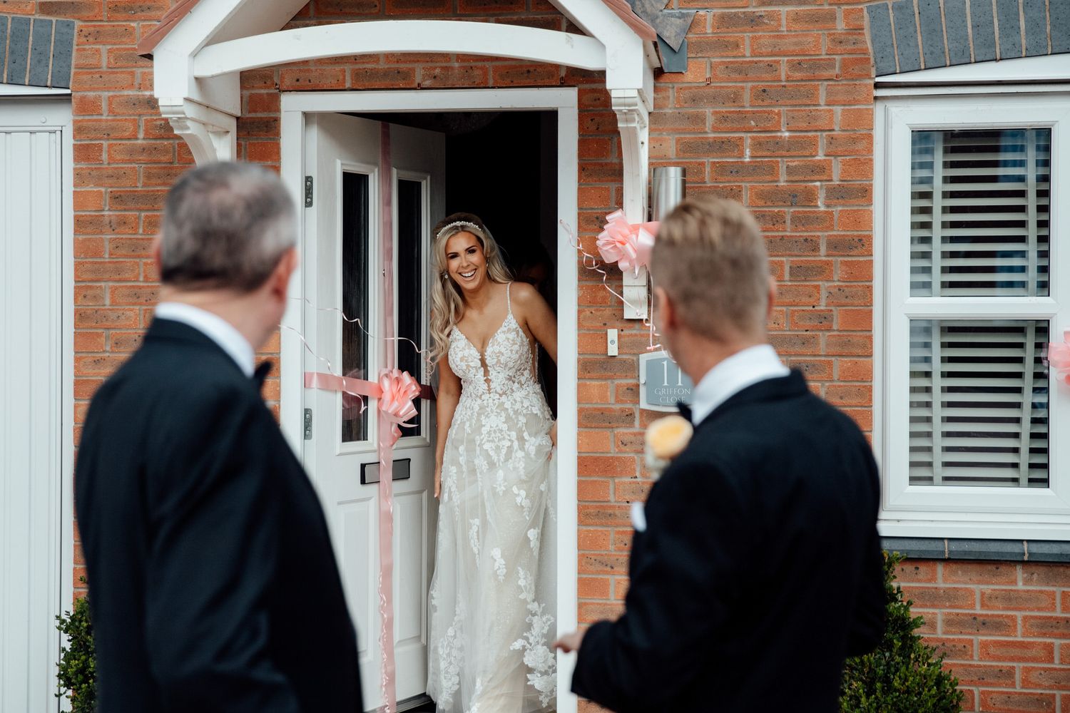 Wedding preparations outside a classic red brick house with white trim.