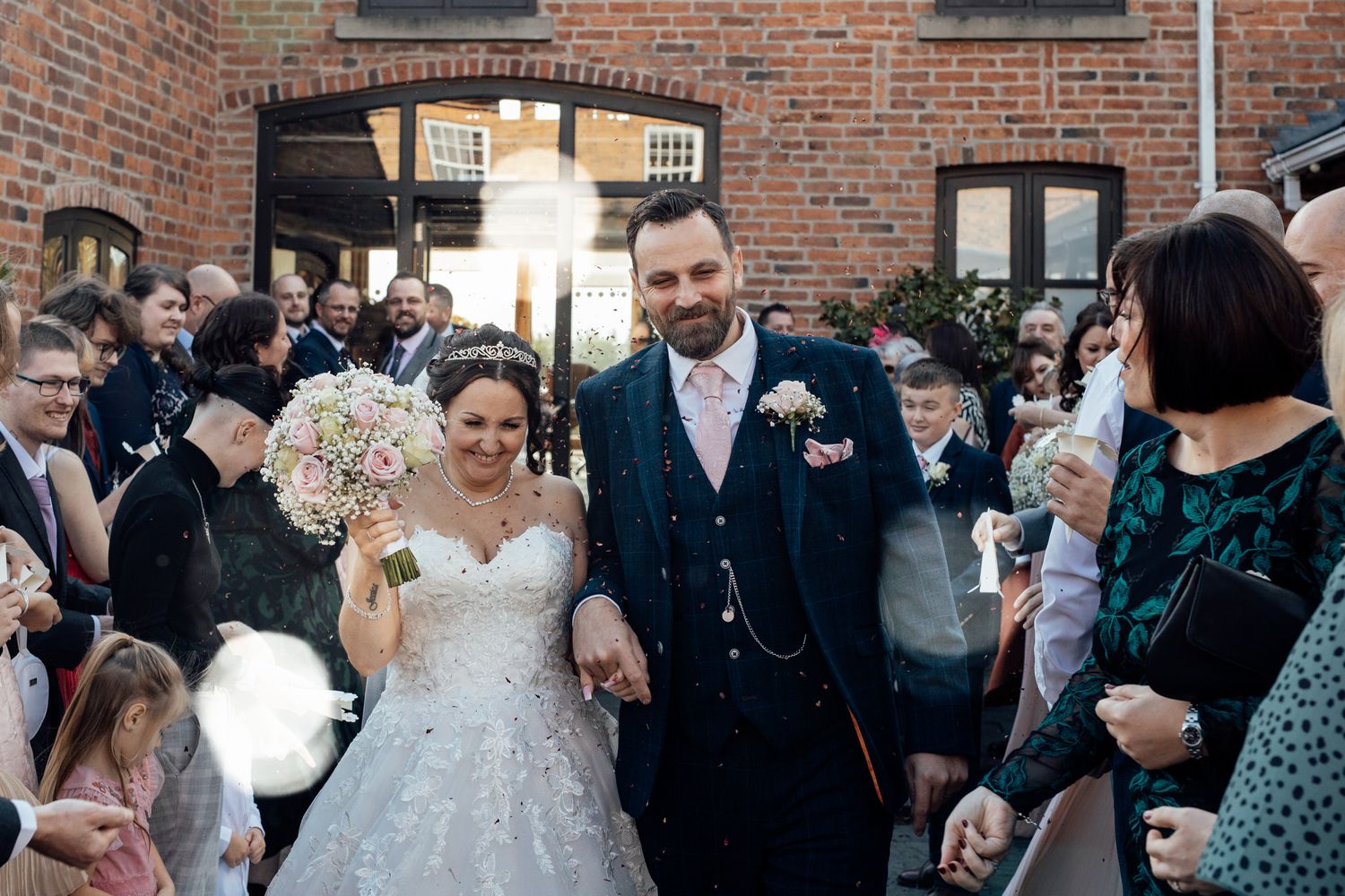 Wedding guests gather in historic brick venue during reception celebration.