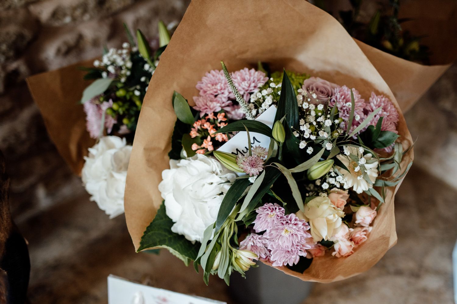 Beautiful bouquets wrapped in kraft paper featuring pink and white flowers with greenery.