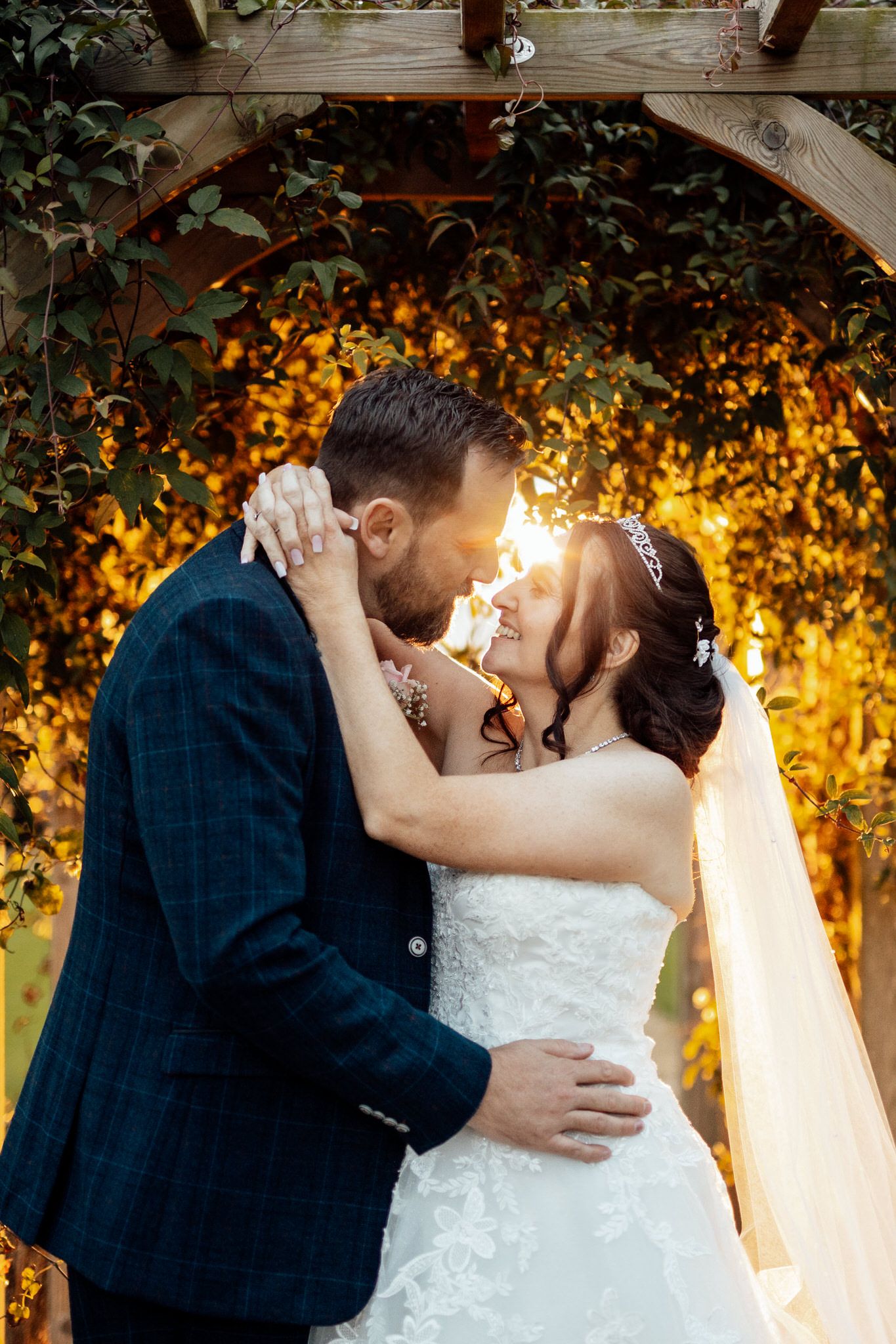 Romantic wedding moment captured against a glowing autumn backdrop with golden foliage.