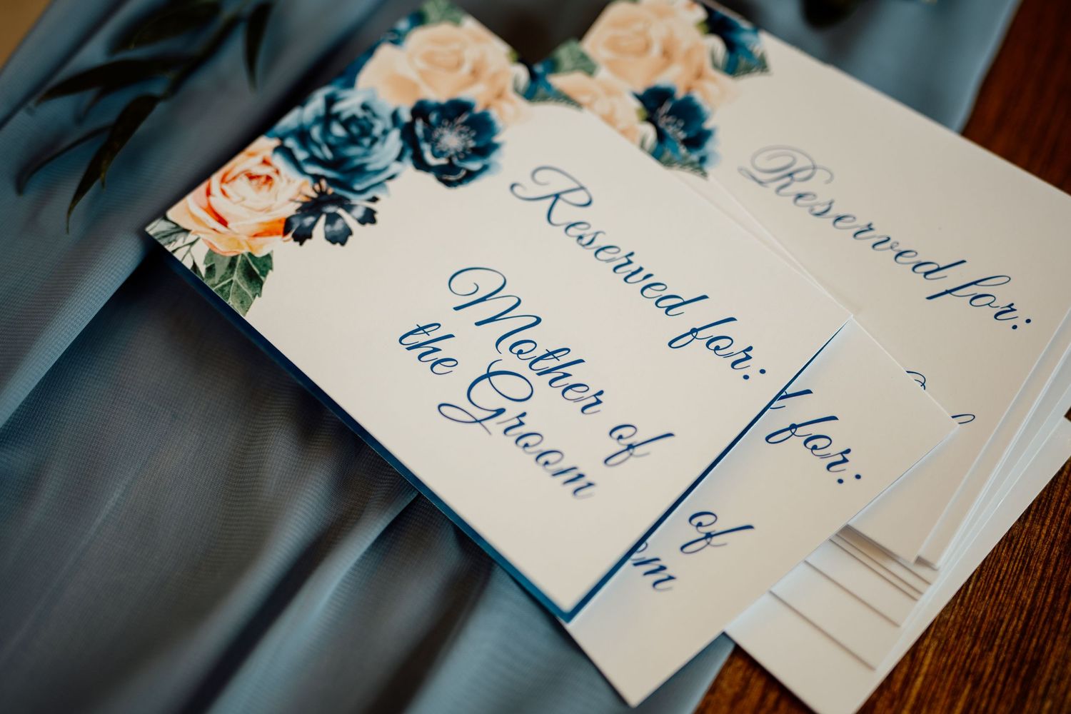Handwritten place cards with elegant calligraphy displayed at wedding reception.