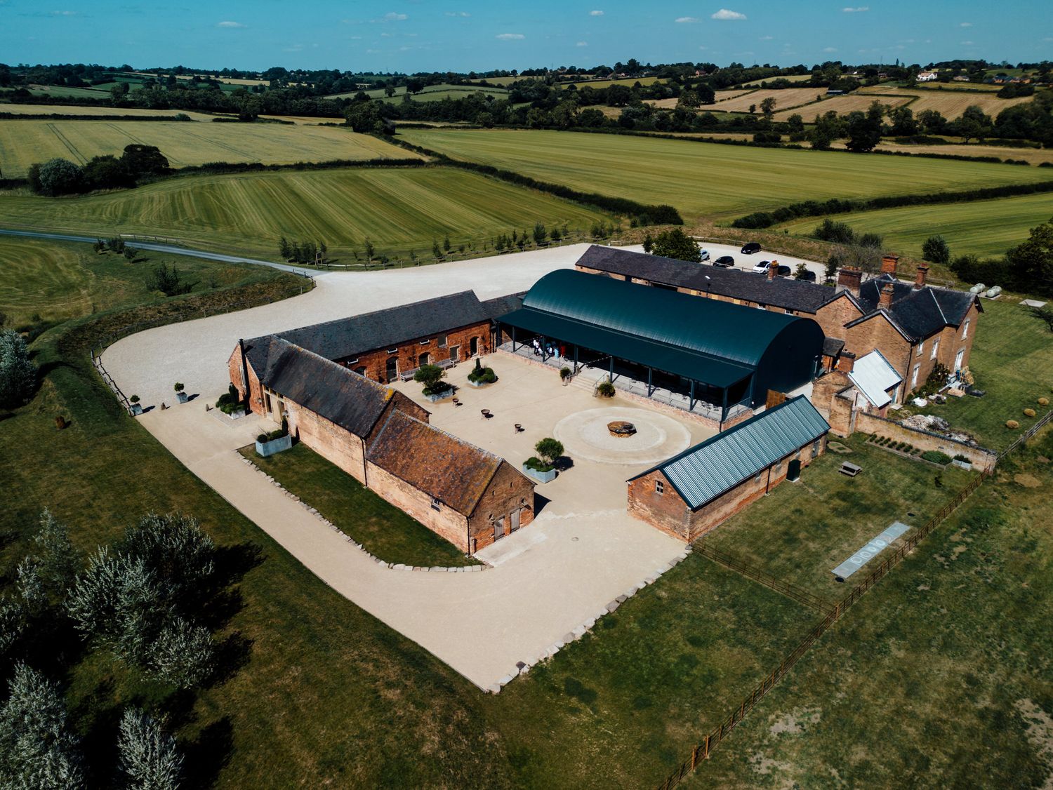 Drone shots of a converted barn wedding venue surrounded by green countryside.