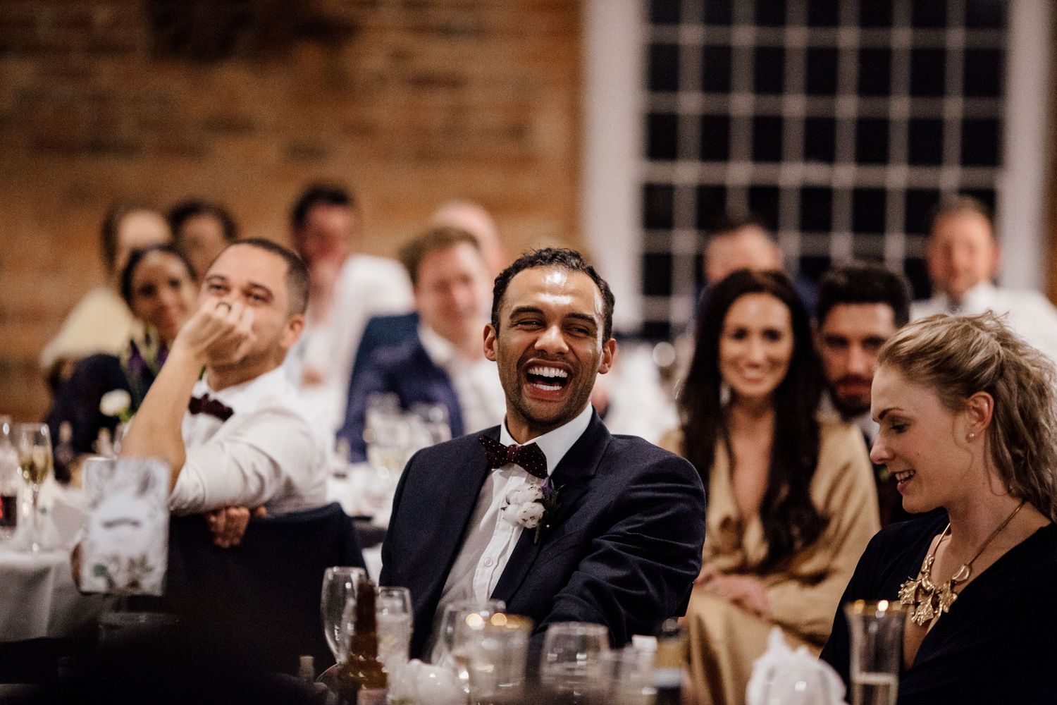 Wedding guests enjoying a lively celebration at a rustic brick venue.