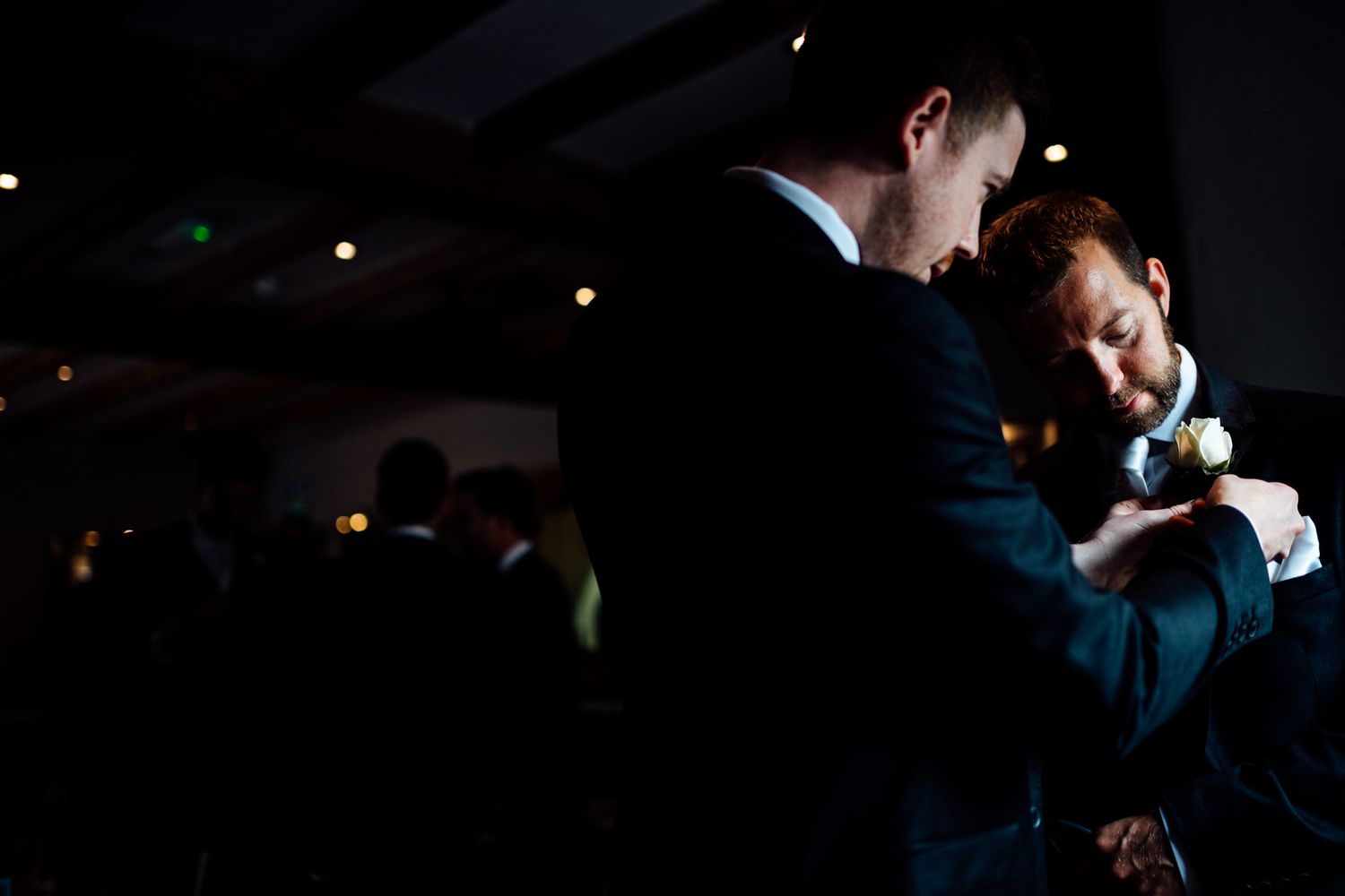 Dark event space with dramatic lighting and silhouettes of people dancing.