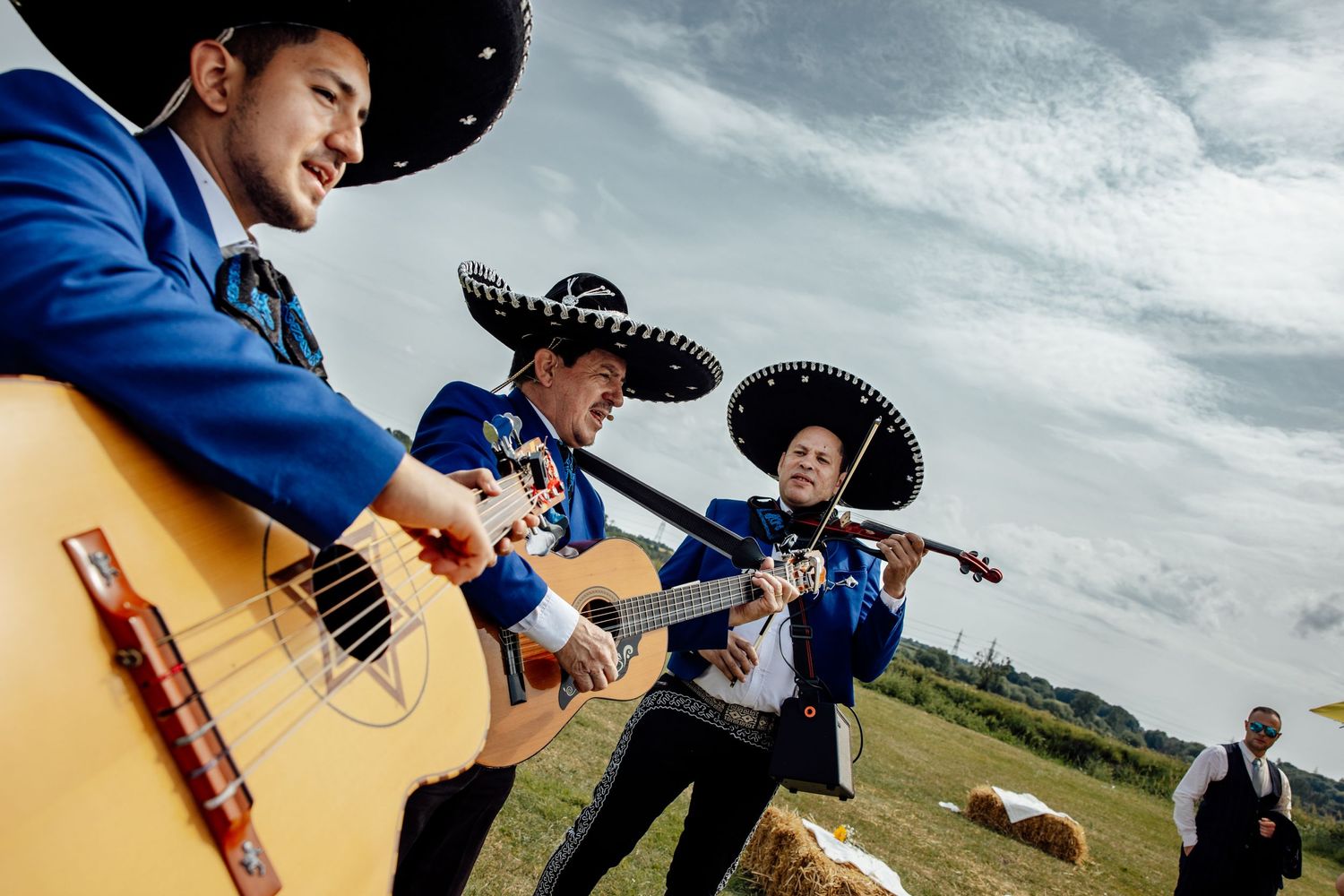 Wedding party members in cowboy hats posing playfully in outdoor setting.