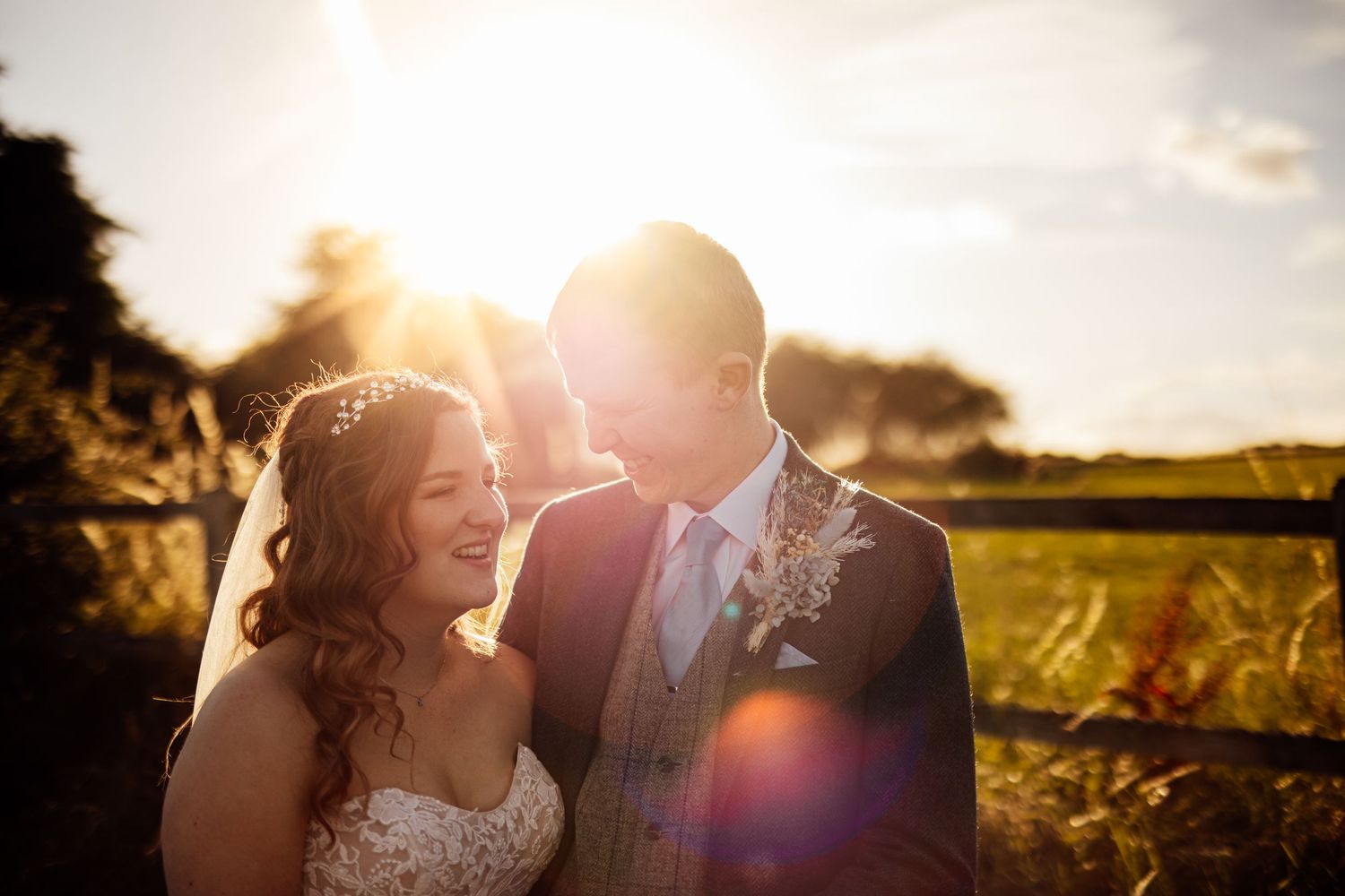 Romantic sunset portrait in a golden field with lens flare.