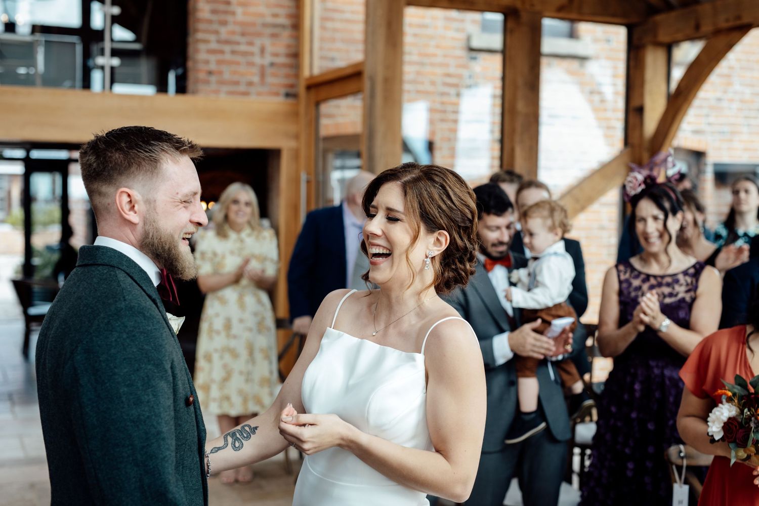 Guests mingle and celebrate at rustic wedding venue with exposed brick walls.