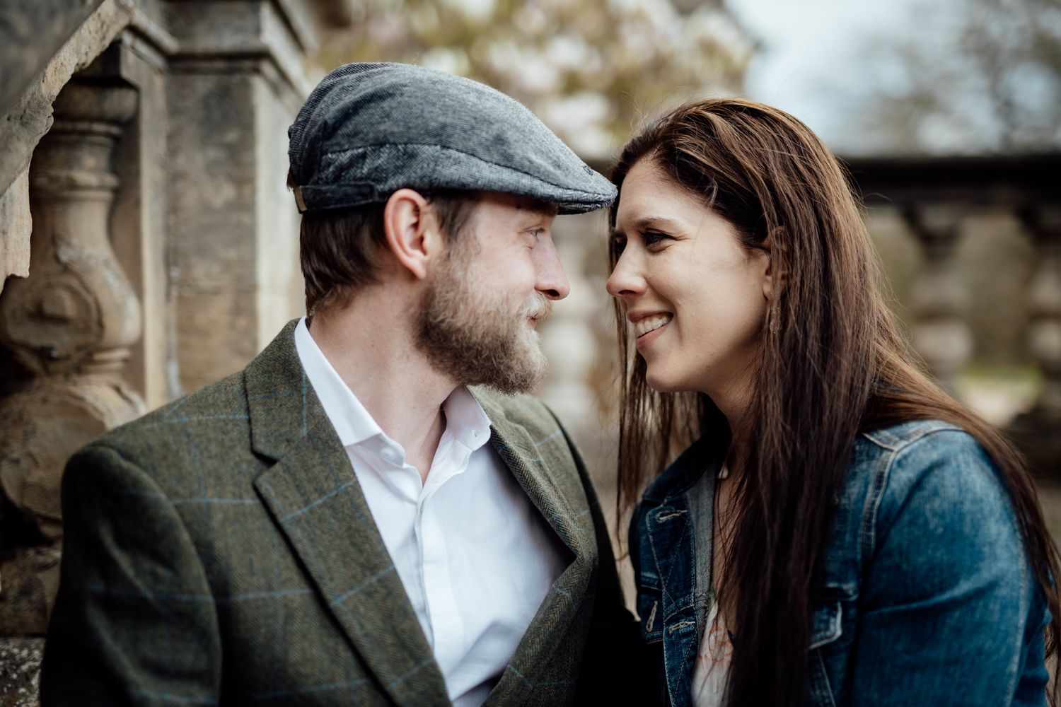 A romantic moment captured between two people against a brick wall background.
