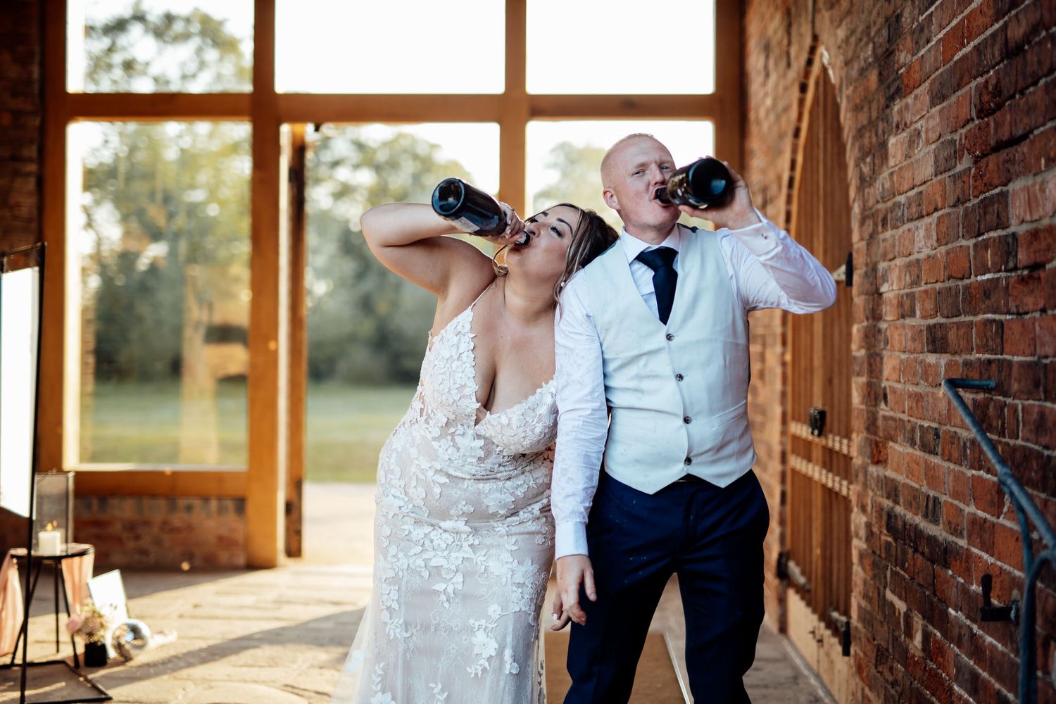 Rustic brick venue interior with large windows and natural sunlight streaming in.