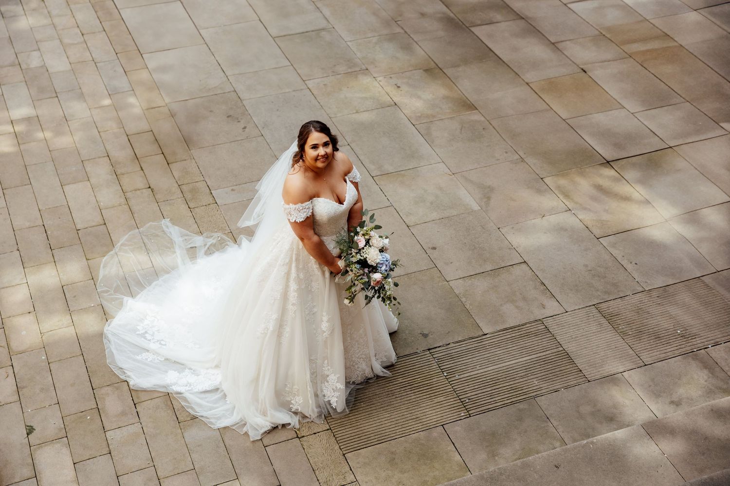 Elegant bridal portraits on stone tile courtyard.